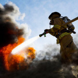 Firefighter spraying water on a fire