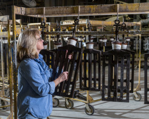 Post Precision employee examining an apparatus