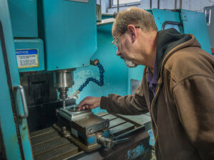 Post Precision employee checks on the milling process